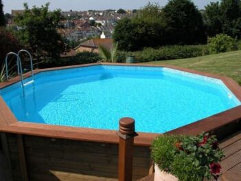 Clear blue water in an above ground wooden swimming pool.