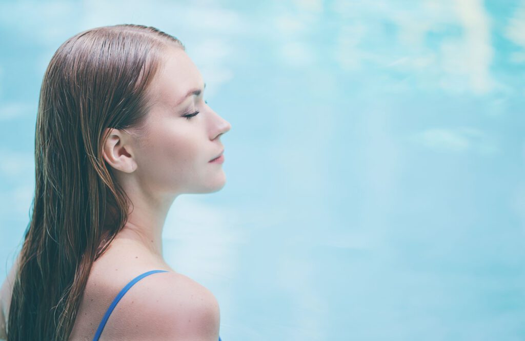 A women soothes away back pain in a warm hot tub to promote better sleep