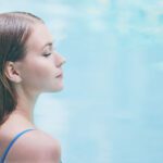 A women soothes away back pain in a warm hot tub to promote better sleep