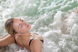 A women de-stresses her worries away whilst relaxing a hot tub