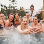 Friends unwind and party in a hot tub in Surrey, Uk.