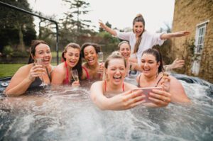 Friends unwind and party in a hot tub in Surrey, Uk.