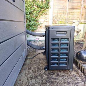 side view of a heat pump next to a hot tub